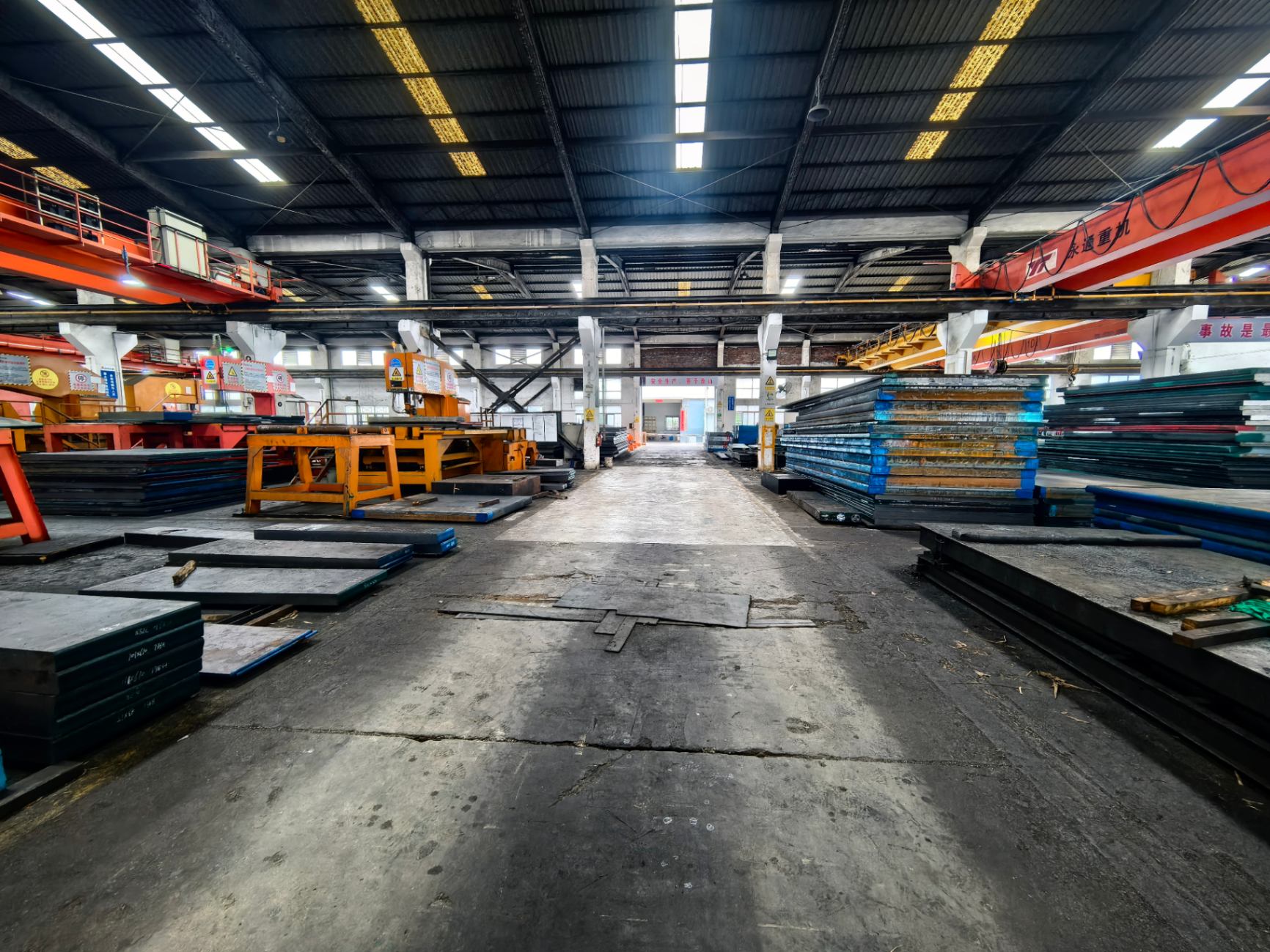 Steel processing workshop with gantry cranes and milling machines